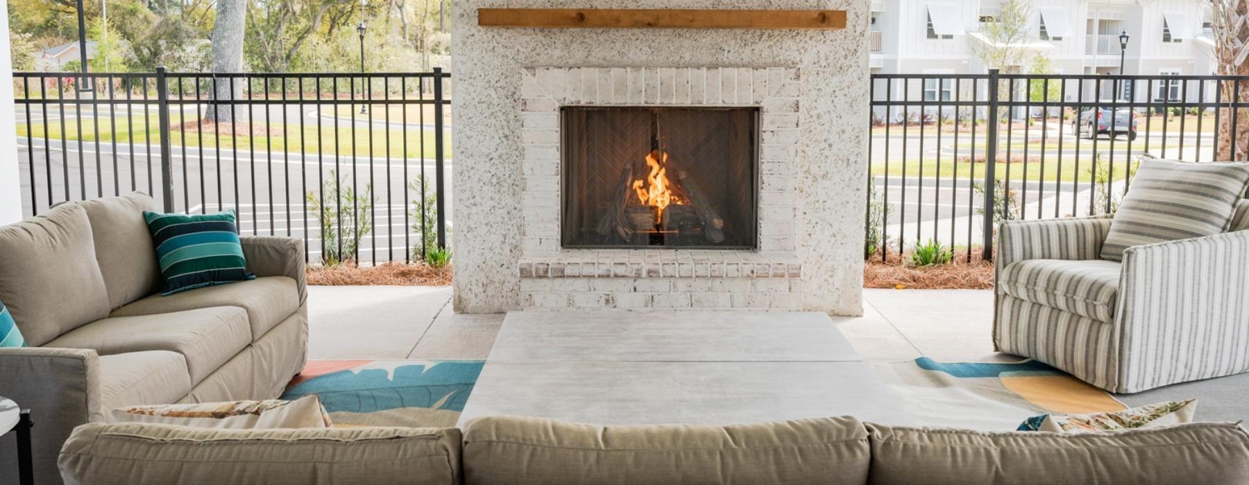 an outdoor fireplace with chairs and a couch