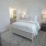 a bedroom with a bed and a mirror and a rug